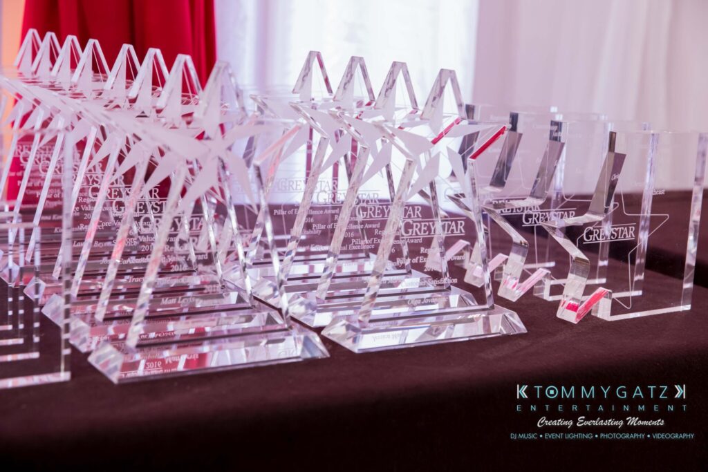 A collection of star-shaped glass awards on a table, displaying the Greystar logo.