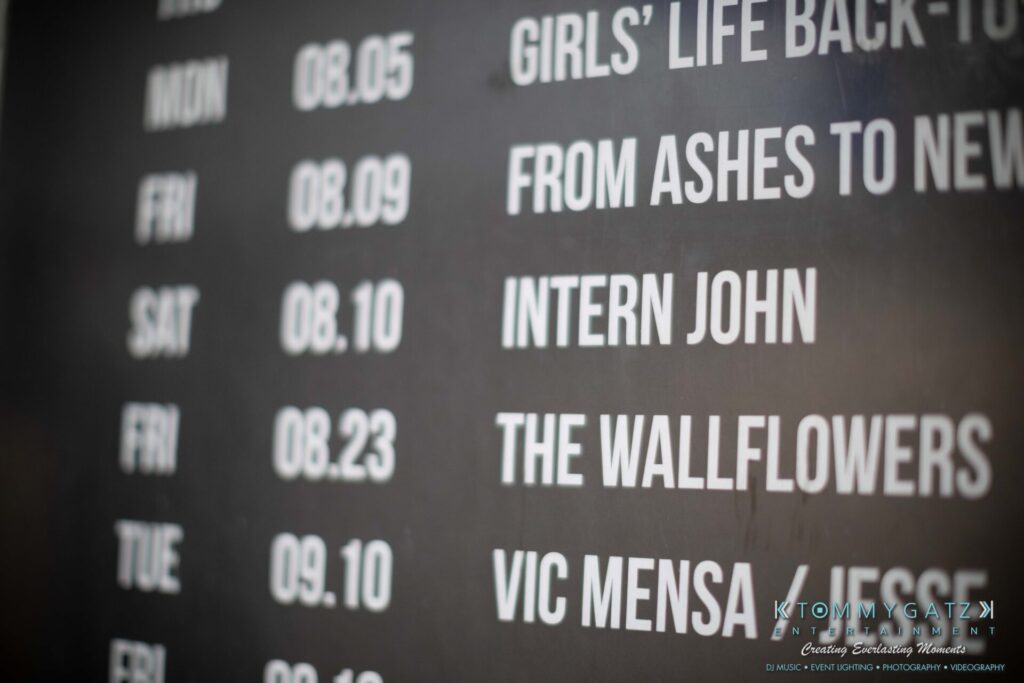 Close-up of a concert schedule board displaying events and dates, including "Intern John," "The Wallflowers," and "Vic Mensa.