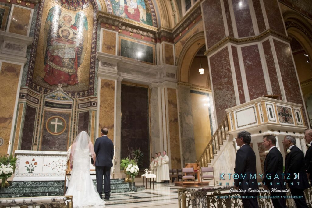 Bride and groom standing at the altar in a large, ornate church as guests watch.