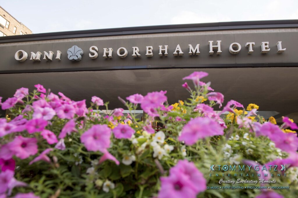 Flower bed with pink and purple blossoms in front of the Omni Shoreham Hotel entrance.