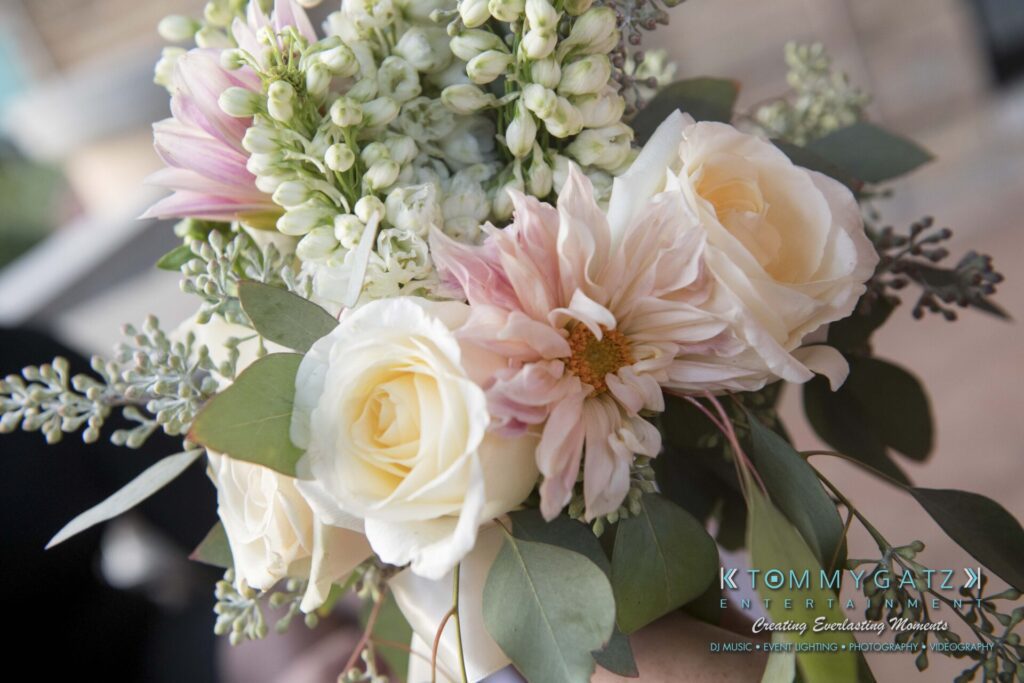A bouquet with white roses, pale pink flowers, and greenery.