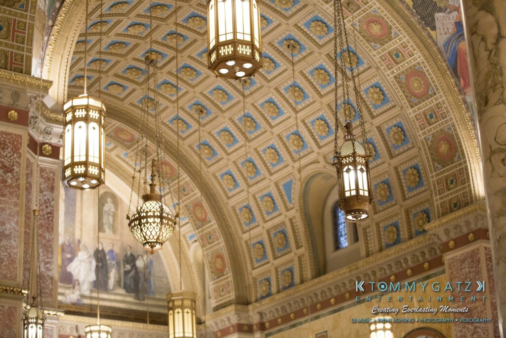 Ornate interior ceiling with hanging lanterns, decorated with intricate patterns and classical artwork.