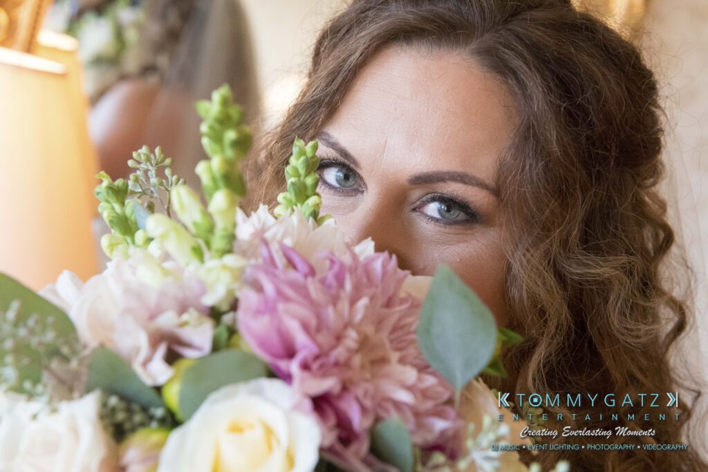 Person holding a bouquet of pink and white flowers, partially covering their face.