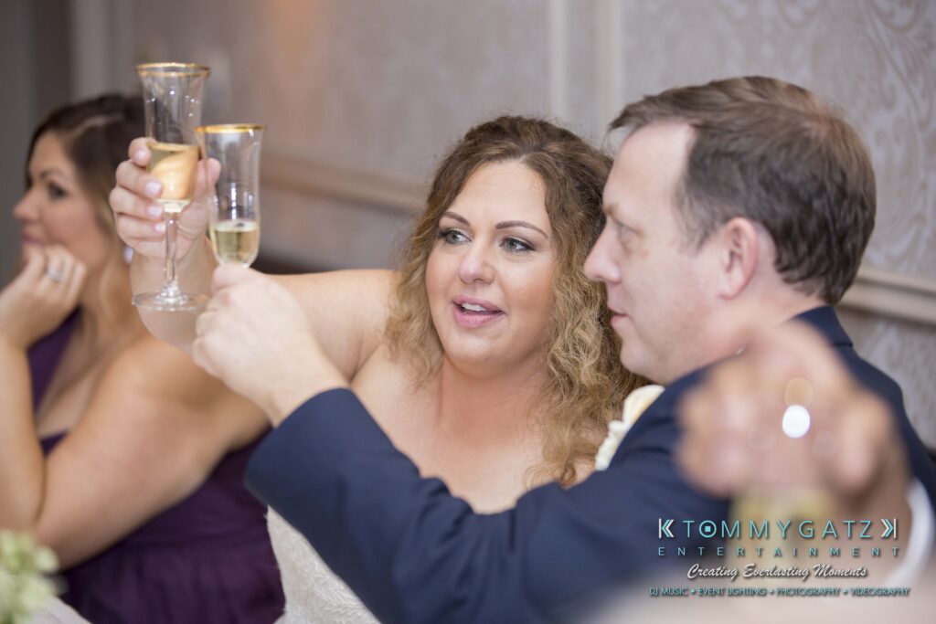People raising champagne glasses in a celebratory toast at an indoor event.