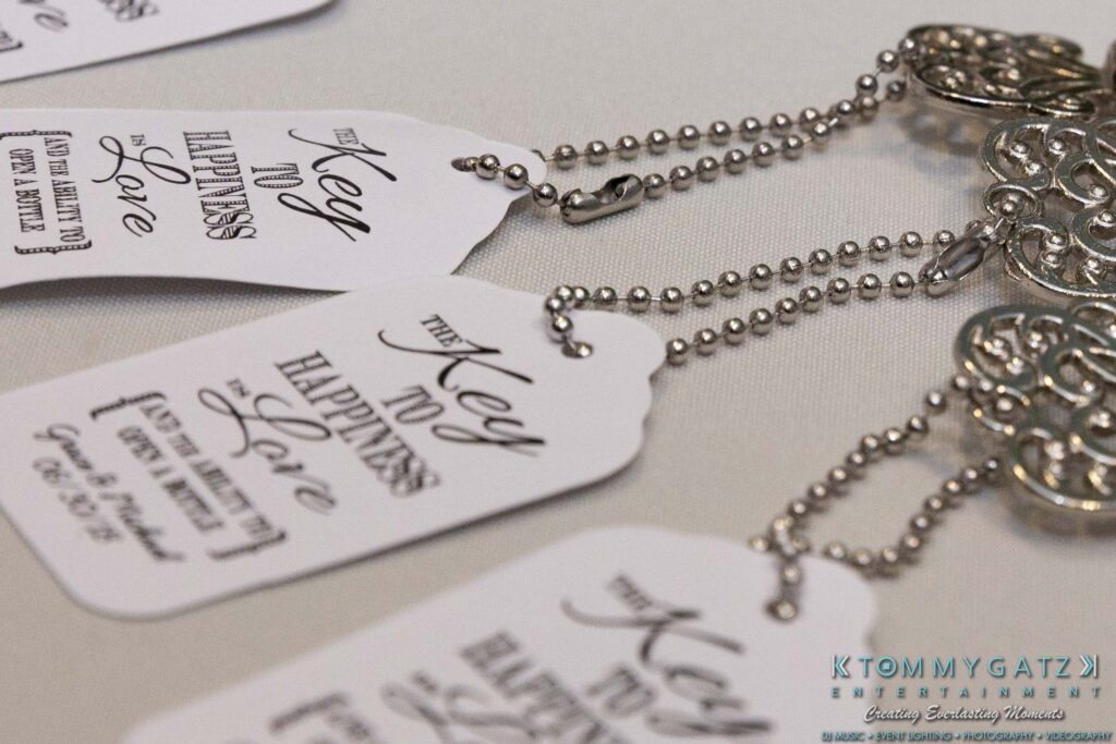 Close-up of decorative key-shaped wedding favors with tags reading "The Key to Happiness is Love.