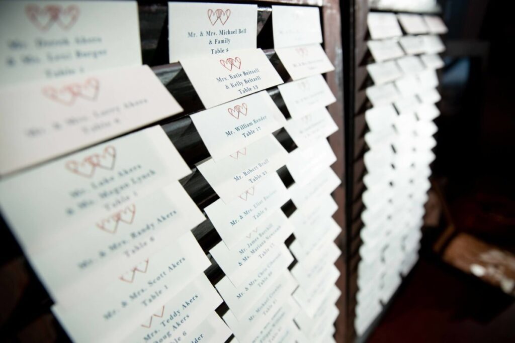 Table place cards organized in rows on a display board with names and table numbers.