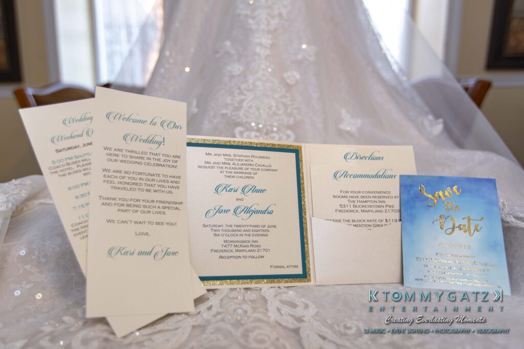 Wedding invitation set on a lace dress, featuring ceremony and reception details alongside a "Save the Date" card.