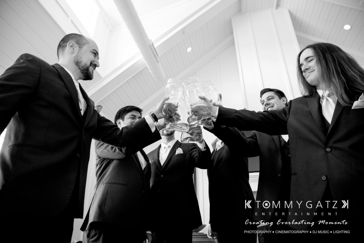 A group of men in suits clink glasses in a celebratory toast under a high ceiling.