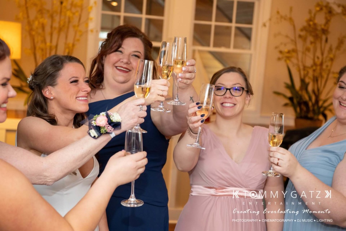 A group of people in formal attire raising glasses in a toast, smiling.