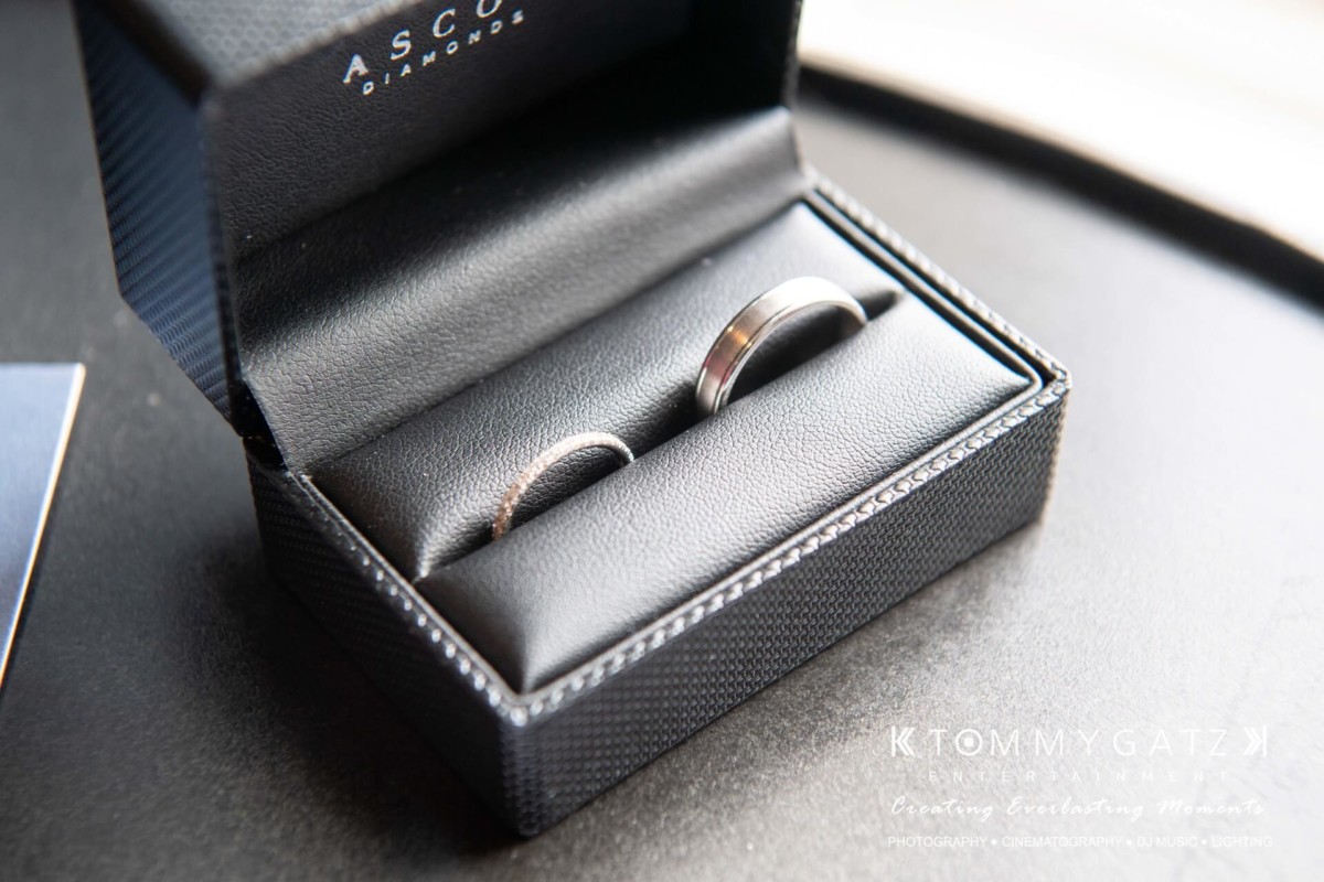 Two silver rings in a black, open jewelry box.